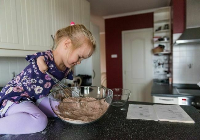 Terapia zajęciowa - umożliwienie dziewczynce z niepełnosprawnością zrobić ciasto.